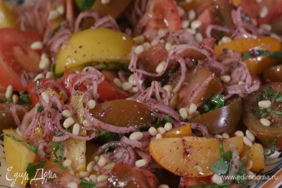 Помидоры посыпать нарезанным базиликом, полить оставшимся оливковым маслом, посолить, поперчить, сверху разложить лук со специями, посыпать салат кедровыми орехами.