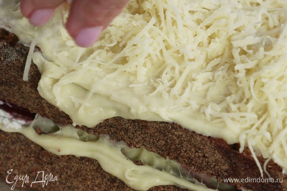 Вторым куском хлеба накрыть первый. Смазать сэндвич сверху бешамелем и посыпать оставшимся сыром. Убрать в духовку под гриль на 2 минуты.