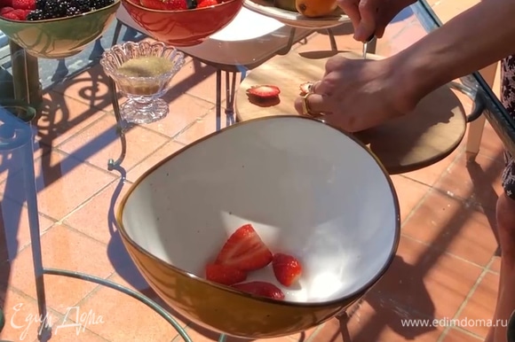У клубники удалить плодоножки, разрезать ягоды на 4 части, положить в миску.