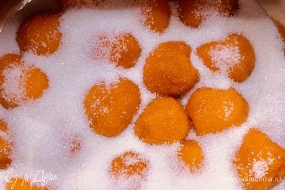 В кастрюлю с толстым дном выложить абрикосы, посыпая слои сахаром.
