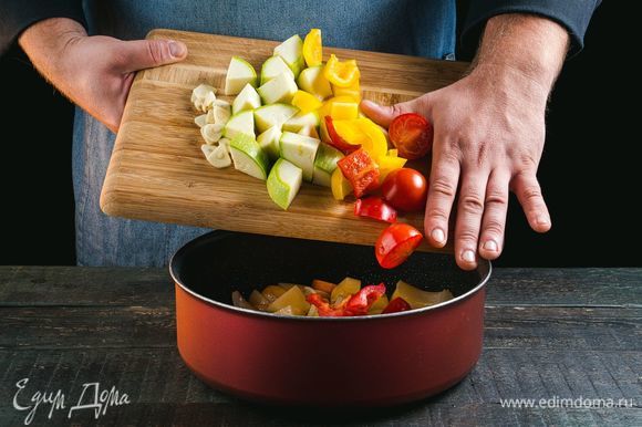 Добавьте к овощам перец, кабачки, помидоры, чеснок. Тушите все вместе на небольшом огне под крышкой 15–20 минут до готовности картофеля. При необходимости добавляйте воду или бульон.