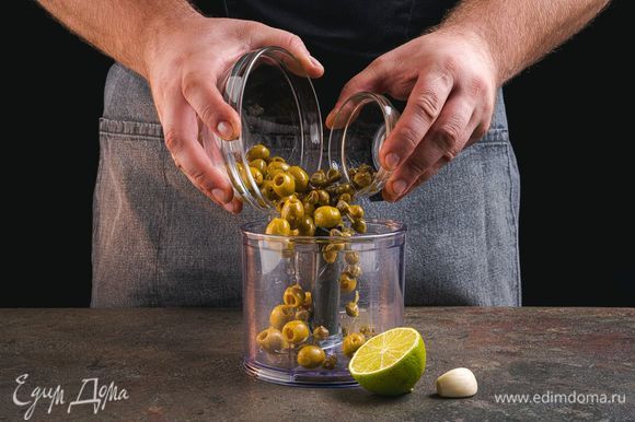 В чашу блендера выложите оливки, каперсы, чеснок, добавьте сок лайма.