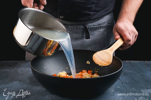 Процеженный бульон налейте в сковороду-вок и доведите до кипения.