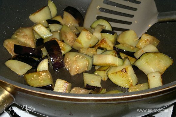 В сковороде разогреть часть растительного масла. Обжарить (частями) кусочки баклажанов до румяности. Выложить баклажаны в кастрюлю.