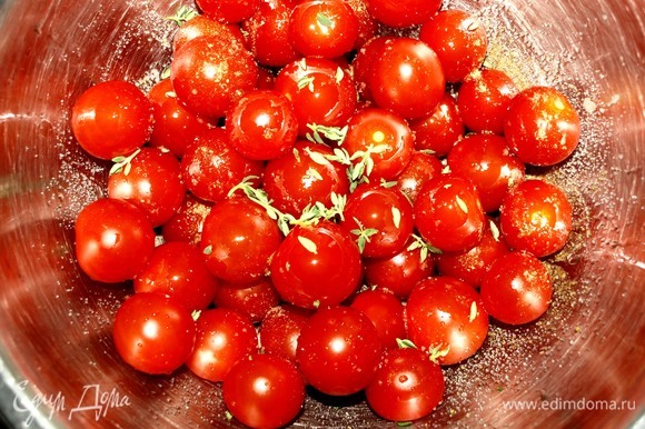 Подготовленные помидоры черри складываем в миску. Добавляем соль, перец, листики 1 веточки свежего тимьяна, растительное масло. Аккуратно перемешиваем.