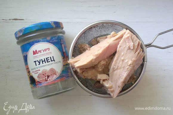 Открыть банку с консервированным филе тунца в оливковом масле ТМ «Магуро». Выложить рыбу на сито и процедить от масла.