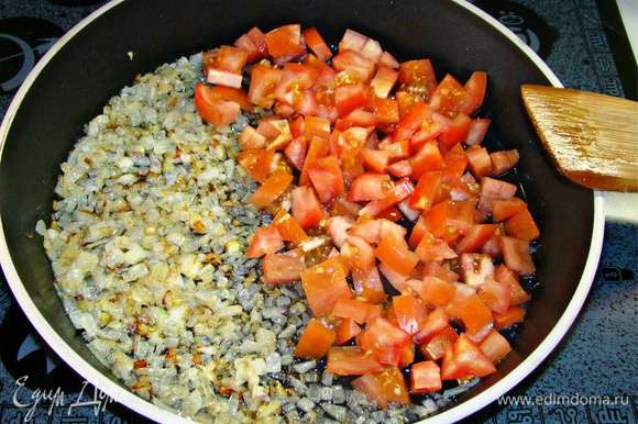 В глубокой сковороде обжарить на растительном масле нашинкованный репчатый лук. К луку добавить мелко нашинкованные помидоры и измельченный чеснок. Все перемешать и обжарить. Если у помидоров грубая кожица, то ее необходимо снять, предварительно ошпарив томаты кипятком.
