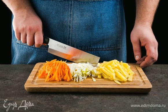 Почистите морковь и картофель, нарежьте соломкой. Лук-порей нарежьте кружочками.