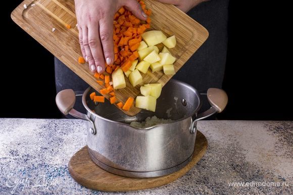 Добавьте нарезанные морковь и картофель в кастрюлю. Слегка обжарьте.