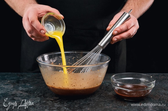 Влейте в тесто растопленный шоколад и масло, оставьте на 2 минуты, а затем перемешайте.