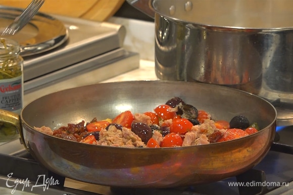 К помидорам добавить оливки, каперсы, перец пеперончино и консервированного тунца. Все перемешать и слегка припустить.