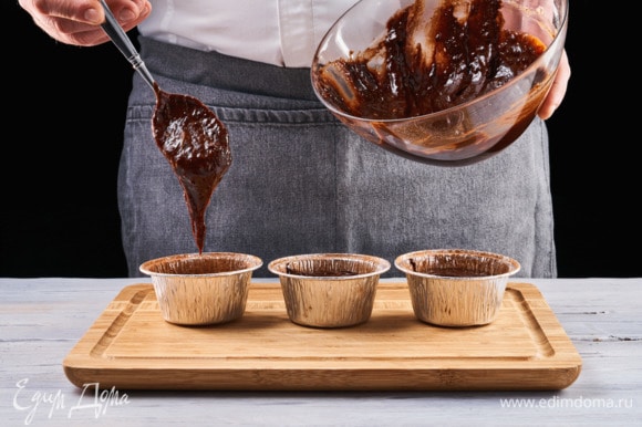 Заранее разогрейте духовку до 200°C. Смажьте формочки для кексов растительным маслом и слегка посыпьте какао-порошком. Наполните формы тестом и отправьте в духовой шкаф на 9 минут.