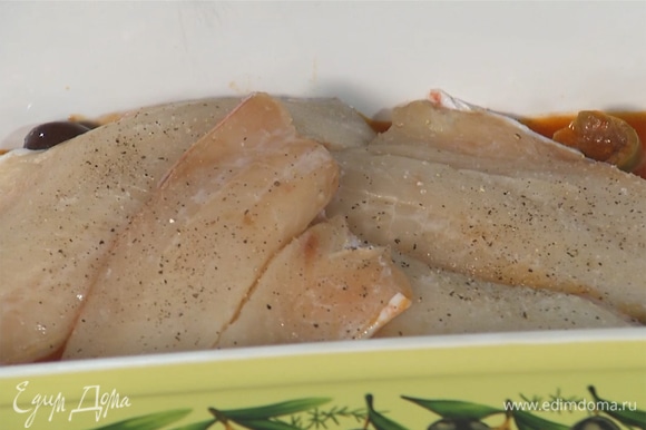 В форму добавить половину соуса, сверху выложить рыбное филе. Посолить, поперчить и посыпать орегано.