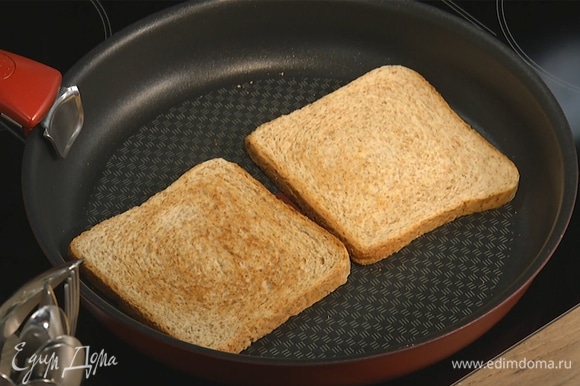 На сухой сковороде подсушить хлеб с двух сторон до образования золотистой корочки. Выложить на тарелку, смазать сливочным маслом.