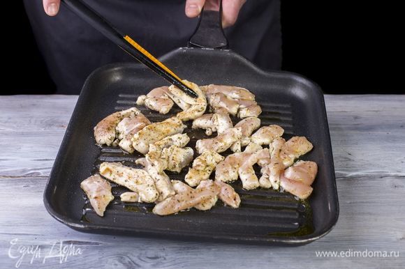 Обжарьте кусочки куриного филе на сковороде-гриль со всех сторон.