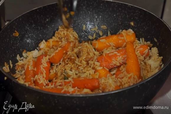 Бланшированную морковь переложить шумовкой в вок с овощами, влить соевый соус, кленовый сироп, все перемешать, добавить рис и помешивая, обжаривать несколько минут, затем снять с огня.