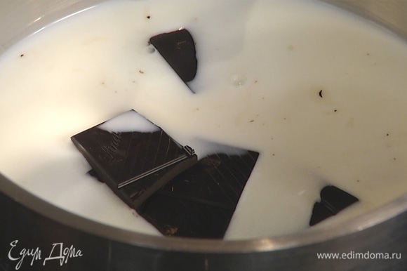 В другой сотейник влить 100 мл молока, добавить темный шоколад, растопить.