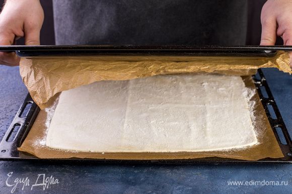 Поверх положите еще один лист пергамента, сверху поставьте противень, чтобы тесто не поднялось. Выпекайте в разогретой до 200°C духовке до готовности (около 20 минут).