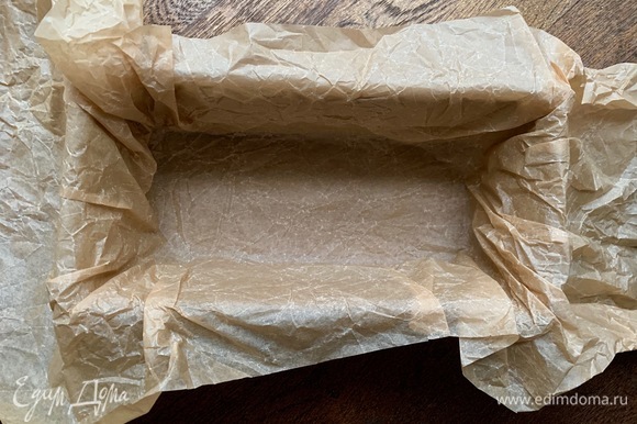 Духовку разогреть до 140°C. Глубокую форму застелить пергаментом так, чтобы можно было краями укрыть кекс.