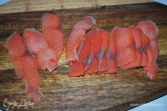Нарежьте тонкими ломтиками красную малосоленую рыбу.