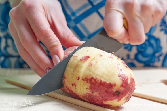Нарежьте картофелины тонкими дольками не до конца. Очень удобно для этого пользоваться бамбуковыми палочками, как ограничителями.