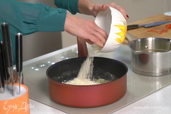 В сотейник добавить рис, обжарить, помешивая, в течение 2 минут — он должен стать полупрозрачным.