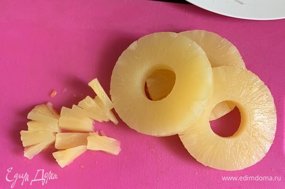 Консервированный ананас (кольцами) откидываем на сито и мелко нарезаем.