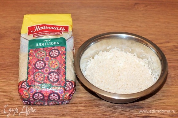 Рис для плова залейте холодной водой и оставьте минут на 30. Затем выложите рис в сито, воду слейте.