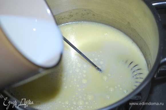 Горячее молоко (350 мл) влейте в желтковую массу и все хорошо перемешайте.