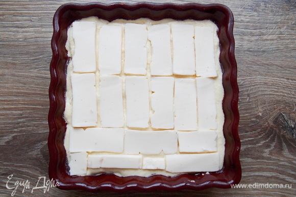 Наливаем еще 1/3 теста и разравниваем, закрывая первый слой сыра. Плавленый сырок тоже режем тонкими пластинками и раскладываем на всю поверхность второго теста. Если не любите сырки, возьмите плавленый сыр пластинками.