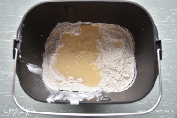 В форму хлебопечки установить насадку для замеса теста, всыпать просеянную муку, добавить заварную смесь.