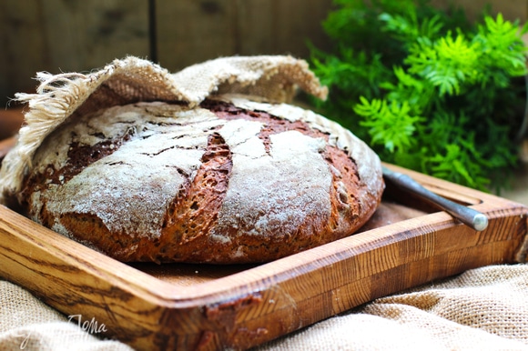 Выпекать хлеб первые 10 минут с паром, затем выпустить пар/убрать емкость с водой, снизить температуру до 200°C и выпекать еще 45–60 минут до готовности.