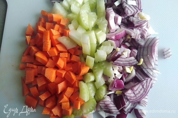 Нарезать сельдерей, лук и морковь. Разогреть масло в сковороде. Готовить овощи 4 минуты, помешивая.