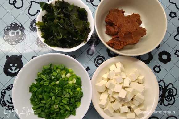 Подготовить ингредиенты: нарезать тофу на квадратики не более 1 см, нашинковать лук, подготовить мисо-пасту. Предварительно необходимо залить холодной водой сухие водоросли вакаме и оставить на 15 минут для набухания.