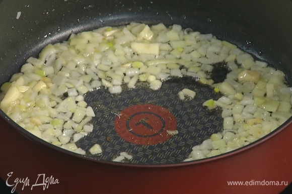Разогреть в небольшой сковороде оливковое масло и обжарить лук с чесноком.