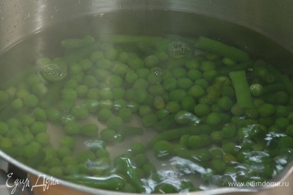 Стручковую фасоль и зеленый горошек разморозить, затем выложить в кастрюлю с кипящей водой, через несколько минут добавить спаржу и варить все еще несколько минут.