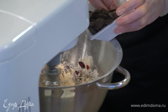 Клюкву и шоколадные капли выложить в тесто, вымешать все лопаткой.