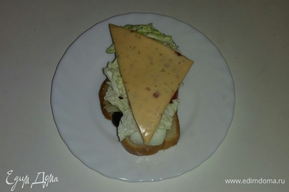 На каждый кусочек хлеба кладем треугольный кусочек сыра. Выкладываем все бутерброды на противень и ставим его в разогретую до 170°C духовку на 7–8 минут (время выпечки зависит от вашей духовки). Бутерброды готовы. Приятного аппетита!