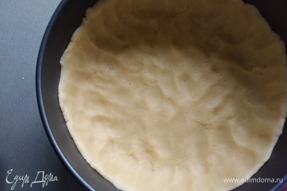 Взять разъемную форму для выпечки диаметром 20–22 см. Тесто распределить по дну формы, сделав невысокие бортики. Убрать в морозилку на 10–15 минут.