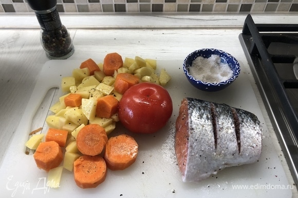 Крупно режем картофель, морковь, делаем надрезы на лососе и помидоре, сбрызгиваем маслом, солим, перчим.