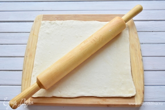 Слоеное дрожжевое тесто разморозить и раскатать в одном направлении в прямоугольник толщиной не менее 0,3 мм.