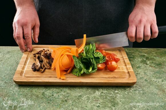 Нарежьте черри пополам, морковь нарежьте на овощечистке, шиитаке нарежьте полосками, шпинат крупно порубите.