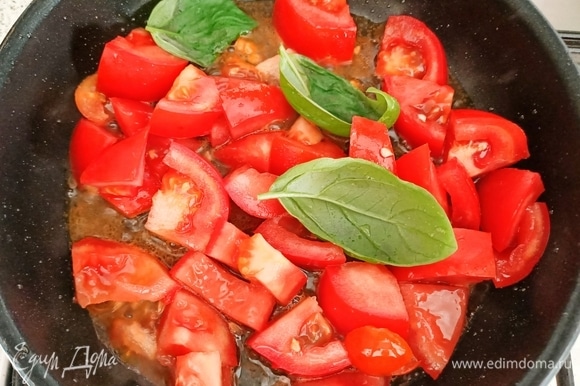 Добавить помидоры и листья базилика. Тушить 3–4 минуты на слабом огне.