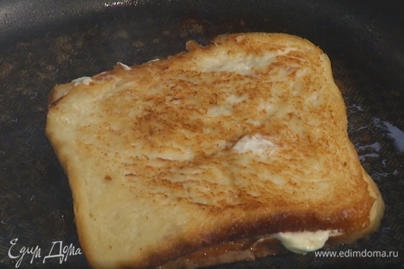 Разогреть в сковороде сливочное масло и слегка обжарить тост с двух сторон, перед подачей разрезать пополам.