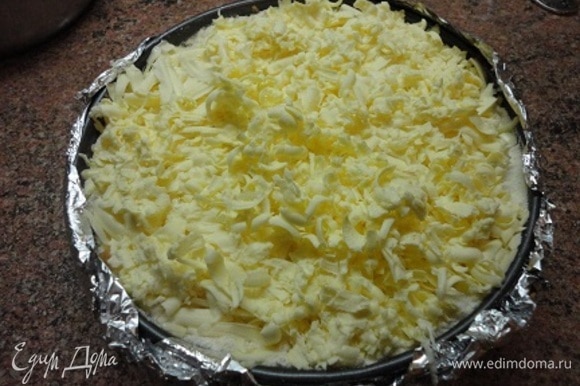 Холодное сливочное масло натереть на крупной терке и равномерно распределить по поверхности пирога.