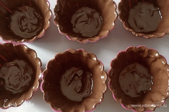 Силиконовые формы покрыть изнутри шоколадом. Поставить в холодильник на 30 минут.