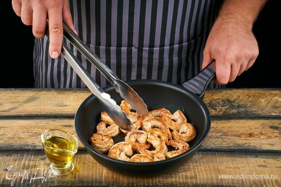 Пожарьте креветки на сковороде в оливковом масле около 2 минут.