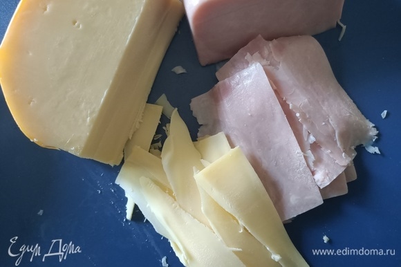 Тонко нарезать сыр и ветчину.