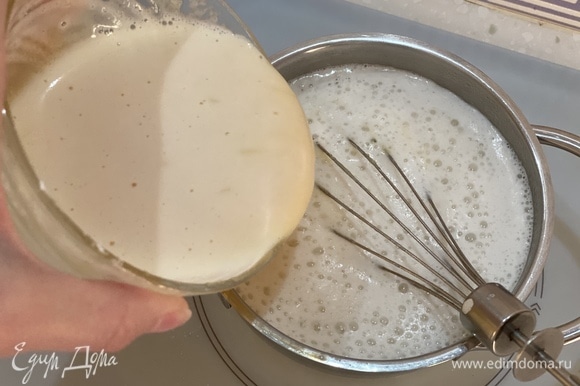 Часть горячего молока медленно влить в яичную смесь. Перемешивать до однородности. Затем влить в кастрюлю с оставшимся молоком.