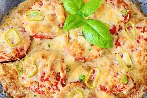 Готовую пиццу достать из духовки, дать пропитаться минут 5–10, украсить зеленым базиликом и подавать.